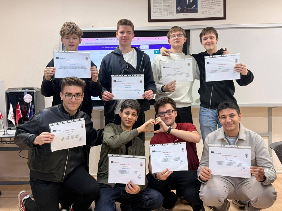 Astoņi jaunieši mācību telpā, daži stāvot, citi tupus, katrs tur rokas priekšā Erasmus+ 